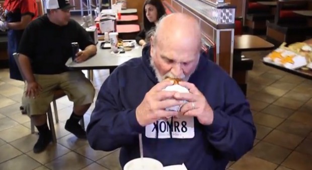Mike Hanline biting into his burger